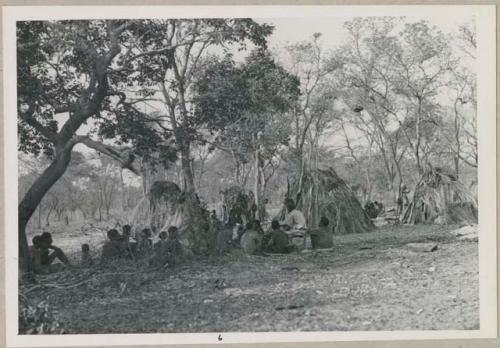 Group of people sitting and being interviewed by Lorna Marshall, with Kernel Ledimo translating (print is a cropped image)