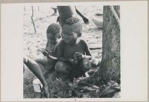 Boy and girl sitting (print is a cropped image; image is flipped)