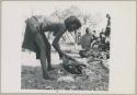 Woman tending a fire (print is a cropped image; image is flipped)