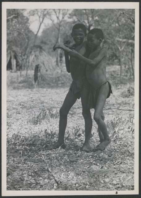 Two girls standing, with their arms around each other (print is a cropped image)