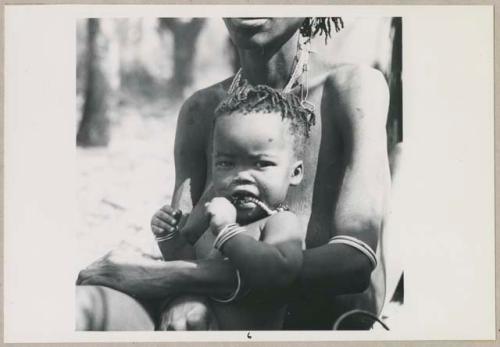 N!ame or Naha, wife of !Kalulu, holding her son, Mishi (print is a cropped image)