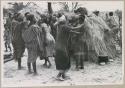 N//aba gesturing; women clapping in a circle, performing the Eland Dance (print is a cropped image)