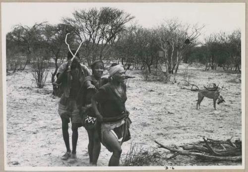 N//aba, !Xoa, and a man holding eland horns walking counter-clockwise, performing the Eland Dance (print is a cropped image)