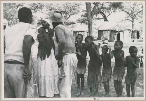 Judas Kangengi and Ananias singing in front of a line of women and boys clapping (print is a cropped image)