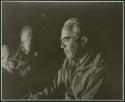 [No folder]: Laurence Marshall and John Marshall by firelight (print is a cropped image)