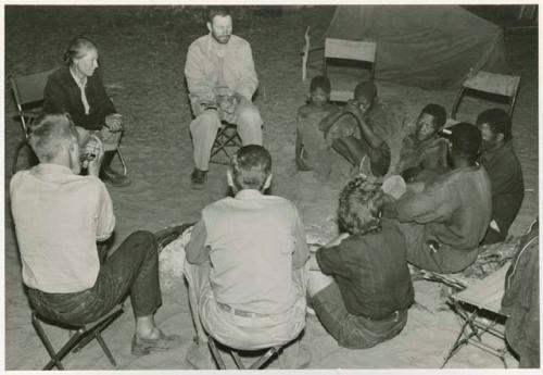 [No folder]: Group of people sitting and talking with expedition members (print is a cropped image)