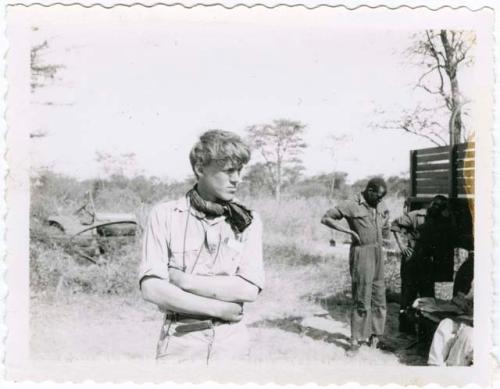 [No folder]: John Marshall standing, with other expedition members and truck in the background