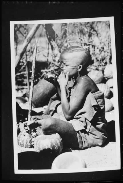 [No folder]: Two women sitting, eating tsama melons