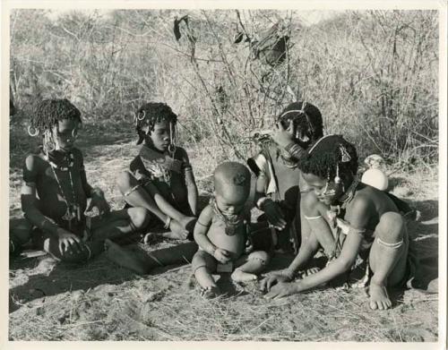 "Little N!ai" (left) and three unidentified girls sitting with !Ungka Norna (center) (print is a cropped image)