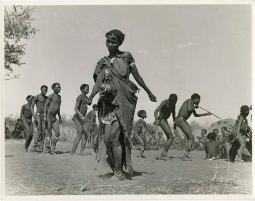 Woman dancing, with a group of people dancing behind her (print is a cropped image)