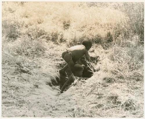 /Gaishay, Bau, and Debe playing in a hole in the ground (print is a cropped image)