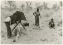 John Marshall filming "/Gao Music" sitting and playing the //guashi and Kernel Ledimo standing to the side (print is a cropped image)











