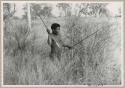 ≠Toma standing in grass with an assegai (print is a cropped image)










