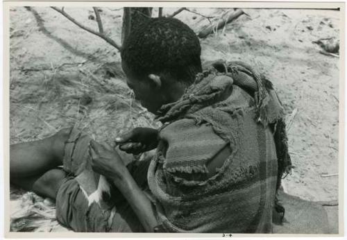 [No folder title]: Tama sewing, showing how he makes a hole with an awl for the thread to go through, close-up (from color slide 2001.29.8361)