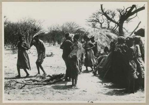 [No folder title]: Group of people performing the Eland Dance, with !Ani followed by Tchobe (from color slide 2001.29.8675)