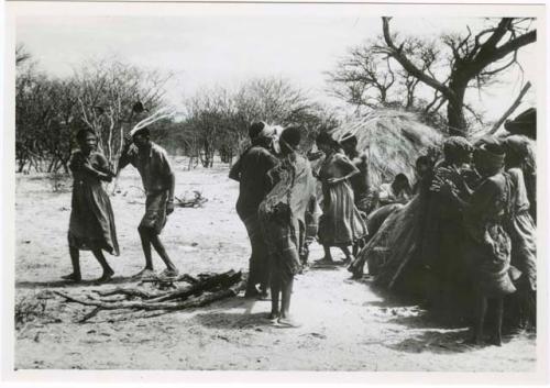 [No folder title]: Group of people performing the Eland Dance, with !Ani followed by Tchobe (from color slide 2001.29.8675)