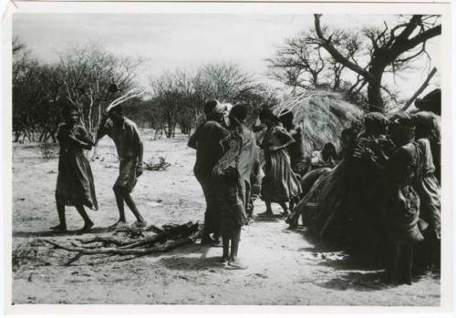 [No folder title]: Group of people performing the Eland Dance, with !Ani followed by Tchobe (from color slide 2001.29.8675)