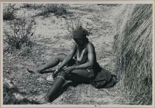 [No folder title]: Woman sitting washing herself from a bowl
