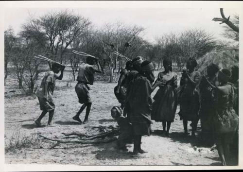 [No folder title]: Group of people performing the Eland Dance; group of women clapping; men holding wooden horns to their heads