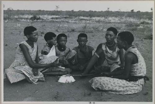 Group of young women sitting, playing a dandiri and singing