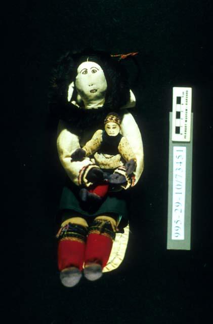 Female doll (A) holding child (B)