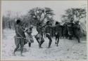 Group of people dancing; a group standing to the side