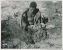 [No folder title]:Oukwane squeezing the stomach contents of gemsbok using a grass sieve


