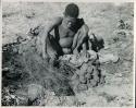 [No folder title]:Oukwane squeezing the stomach contents of gemsbok using a grass sieve


