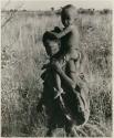 [No folder title]: Tsekue carrying N!whakwe on her shoulder


