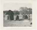 "1950's 400 series": Woman sitting in the doorway of a hut (print is a cropped image)