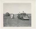 "1950's 400 series": Expedition members standing on and next to trucks (print is a cropped image)