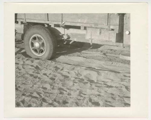 "1950's 400 series": Rear wheel of expedition truck, with sand and chain (print is a cropped image)