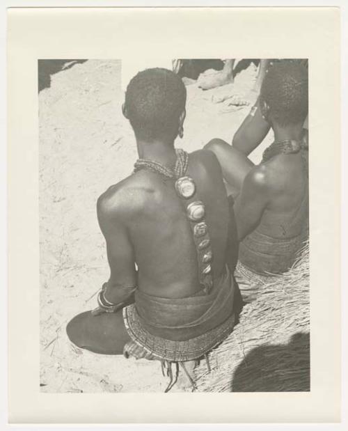 "Glossy duplicates of / 1950 Merl La Voy prints / 400 series": Woman sitting with her back to the camera, wearing ornaments (print is a cropped image)