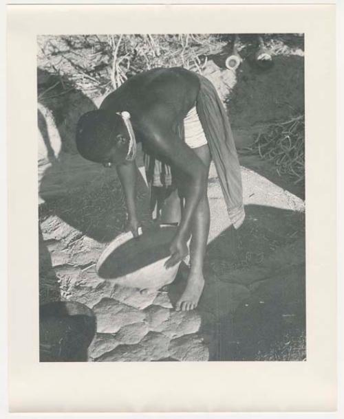 "Glossy duplicates of / 1950 Merl La Voy prints / 400 series": Woman leaning over and holding a basket (print is a cropped image)