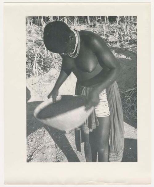 "Glossy duplicates of / 1950 Merl La Voy prints / 400 series": Woman standing and holding a basket (print is a cropped image)