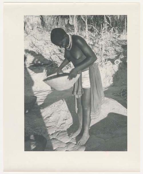 "Glossy duplicates of / 1950 Merl La Voy prints / 400 series": Woman standing and holding a basket (print is a cropped image)