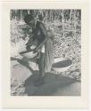 "Glossy duplicates of / 1950 Merl La Voy prints / 400 series": Woman standing and holding a basket of grain (print is a cropped image)