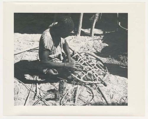 "1950 '400 Series' / 87 B/W prints (some duplicates) / Ovamboland": Person sitting and working, possibly mending a net (print is a cropped image)