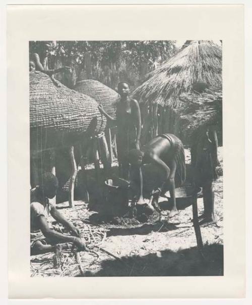 "1950 '400 Series' / 87 B/W prints (some duplicates) / Ovamboland": People working next to storage baskets, one possibly mending a net (print is a cropped image)