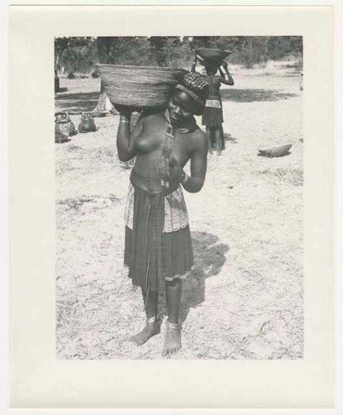 "1950 '400 Series' / 87 B/W prints (some duplicates) / Ovamboland": Woman carrying a basket on her shoulder (print is a cropped image)