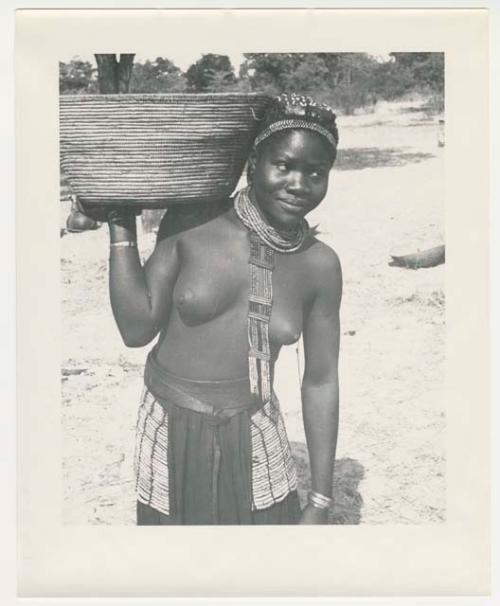 "1950 '400 Series' / 87 B/W prints (some duplicates) / Ovamboland": Woman carrying a basket on her shoulder (print is a cropped image)