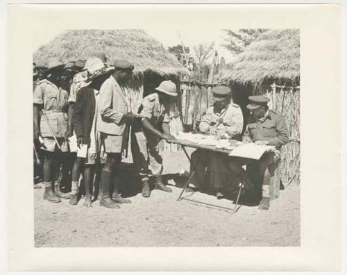 "1950 '400 Series' / 87 B/W prints (some duplicates) / Ovamboland": Government officials collecting grain tax from Ovambo people (print is a cropped image)