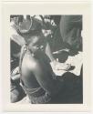 "1950 '400 Series' / 87 B/W prints (some duplicates) / Ovamboland": Woman sitting with a group, close-up (print is a cropped image)