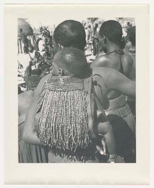 "1950 '400 Series' / 87 B/W prints (some duplicates) / Ovamboland": Woman carrying a child on her back in a beaded carrying bag (print is a cropped image)