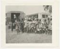 "1950 '400 Series' / 87 B/W prints (some duplicates) / Ovamboland": Large group of people standing in line next to trucks (print is a cropped image)