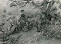 [No folder title]: Women and children of Oukwane's group and “visiting group" sitting under a tree







