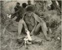 [No folder title]: Elderly woman sitting by her fire







