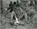 [No folder title]: Elderly woman sitting by her fire







