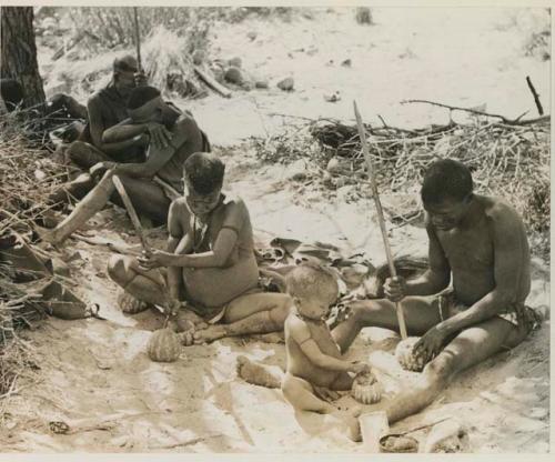 [No folder title]: !Gai's family eating tsama melons (Back to front, left to right: //Ku≠tera, /Twikwe, Taekue, N!whakwe, and !Gai)








