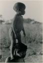 [No folder title]: N!whakwe standing on his mother Tsekue's shoulder to look over the grass to see what was making noise








